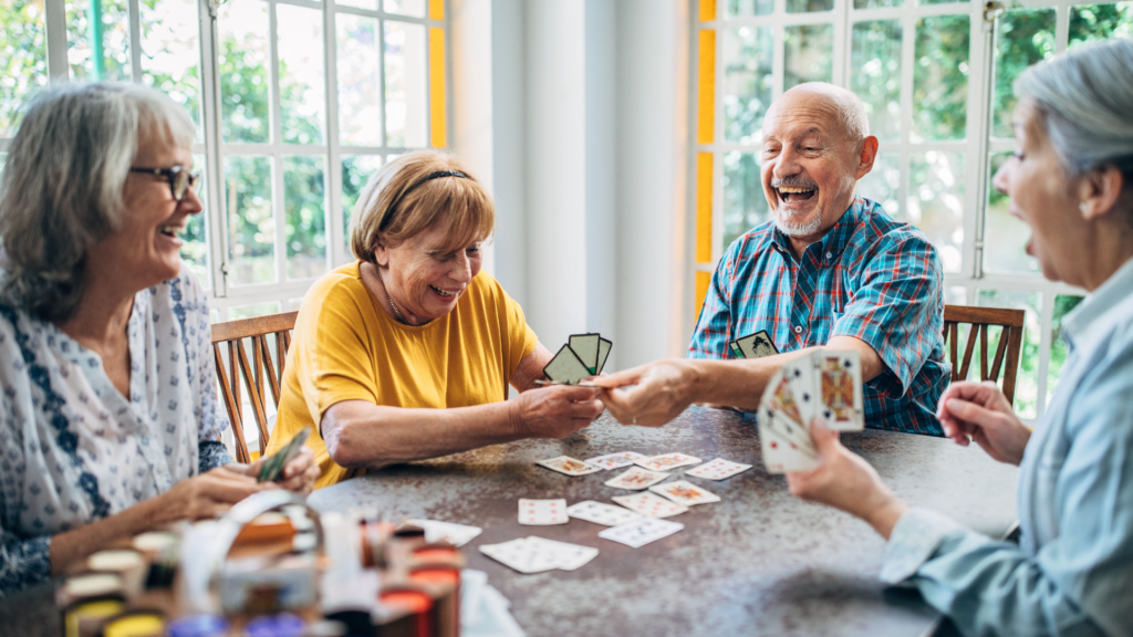 a group of old people playing cards in a welcoming home environment